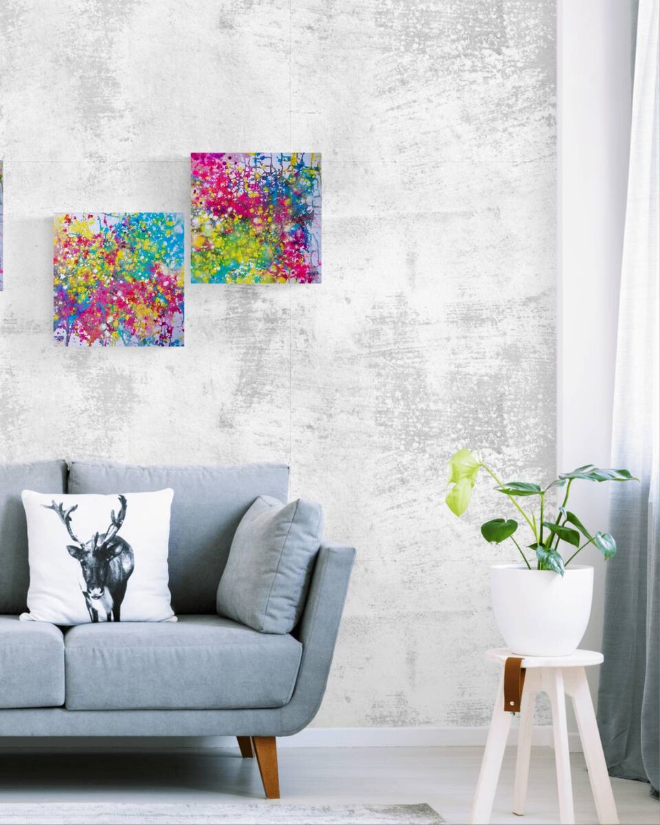 LIFE IS WONDERFUL — A Virtual Fine Art Solo Exhibition by Diana Dimova TRAXI. Art Project inspired by Nature, exploring Time.

 A styled living room scene featuring two colorful abstract canvas prints hanging on a textured light gray wall above a light blue sofa. A white throw pillow with a black deer graphic rests on the sofa, and a potted green plant sits on a small white stool to the right.