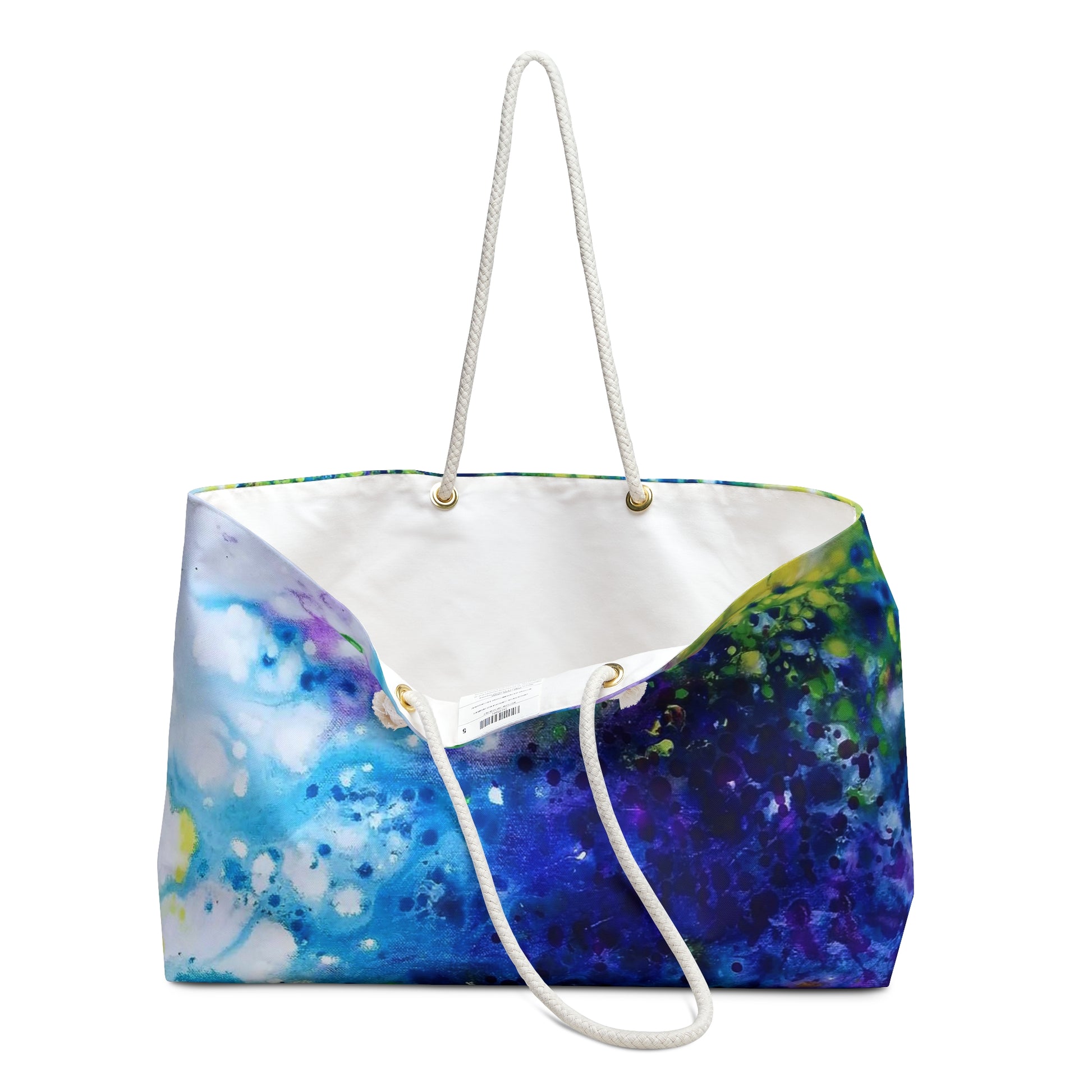 Aromatic lavender symphony beach bag featuring vibrant wearable art inspired by the painting Aromatic Lavender Symphony by Diana Dimova TRAXI. A canvas tote bag featuring a vibrant blue, purple, and green watercolor galaxy print, with a white canvas interior and white rope handles.