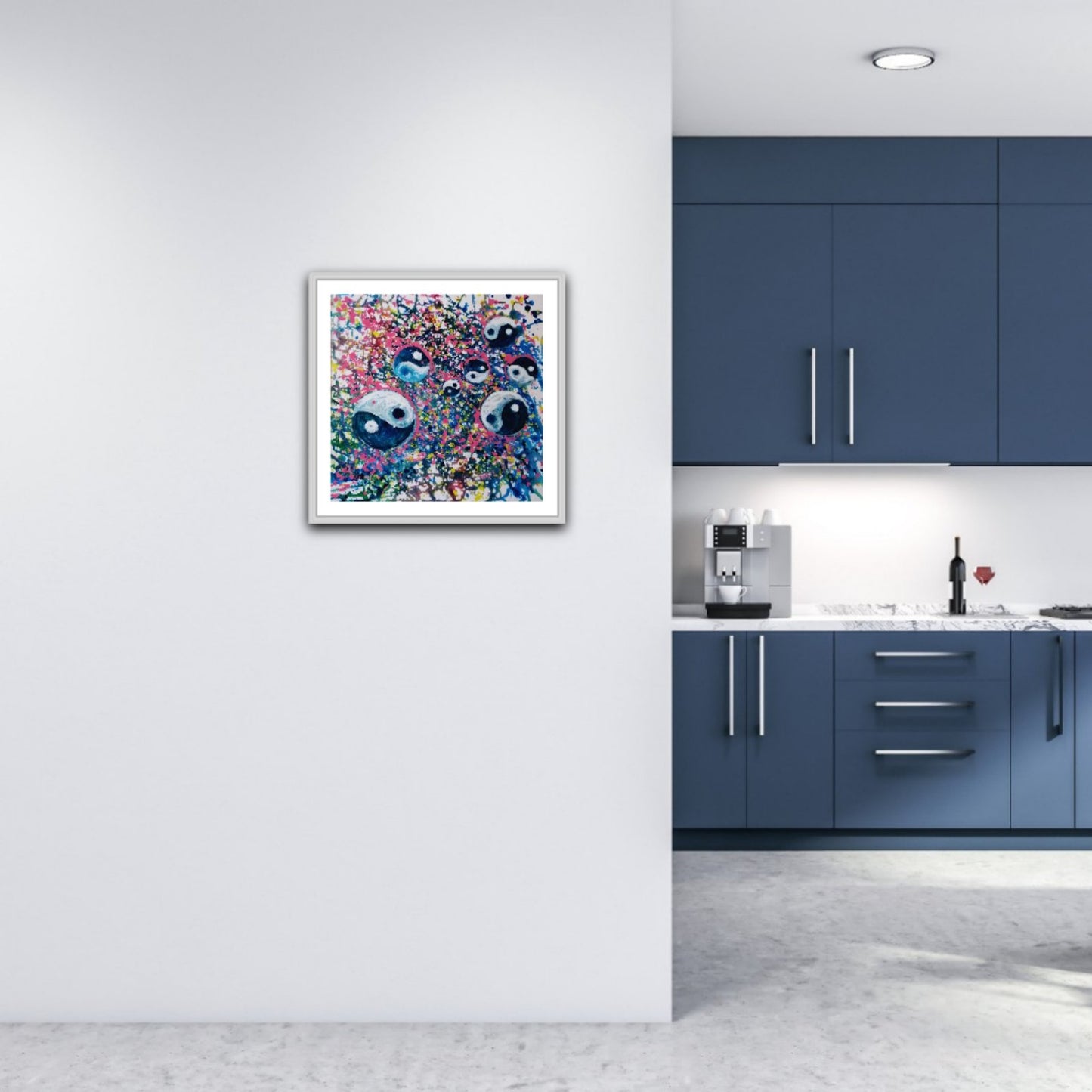Yin Yang spiritual abstract painting titled Events of Life by Diana Dimova TRAXI featuring a circular blue, white, and soft pink composition for modern luxury interiors. A framed abstract art print featuring two stylized faces with large eyes, displayed on a white wall in a modern kitchen setting with blue cabinets.
