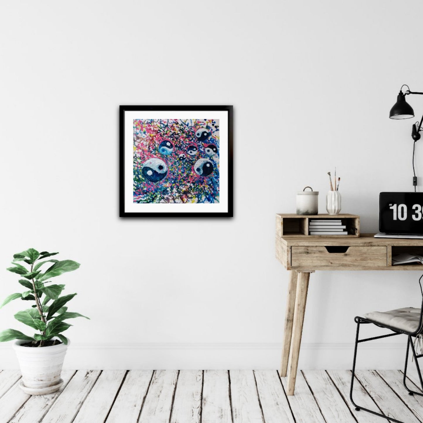 Yin Yang spiritual abstract painting titled Events of Life by Diana Dimova TRAXI featuring a circular blue, white, and soft pink composition for modern luxury interiors. A framed abstract art print featuring two stylized faces with large eyes, displayed on a white wall in a modern room setting with a wooden desk, lamp, and potted plant.