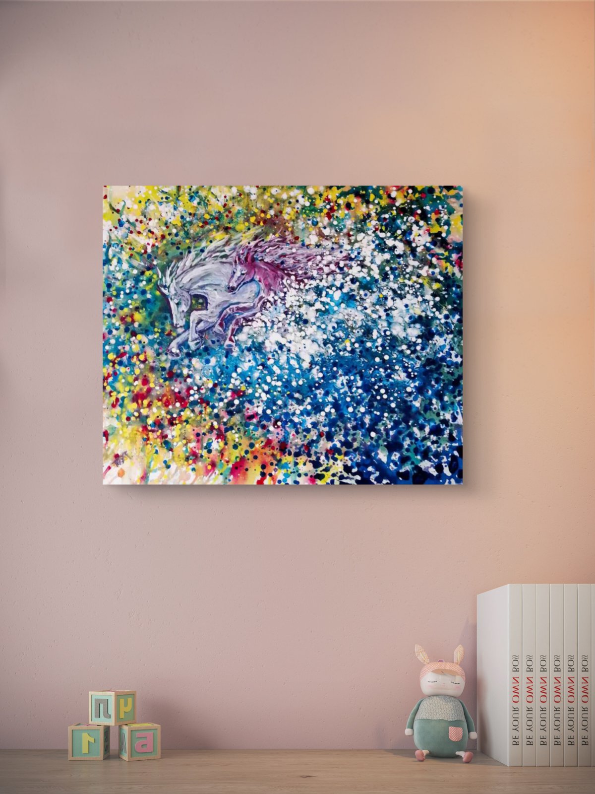 Freedom in color abstract horse original painting by contemporary artist TRAXI, featuring twin horses galloping through a vibrant cosmic nebula sky. A colorful abstract canvas wall art print featuring a stylized horse head, displayed on a light pink wall above a wooden shelf with toy blocks, a plush bunny, and a stack of books.