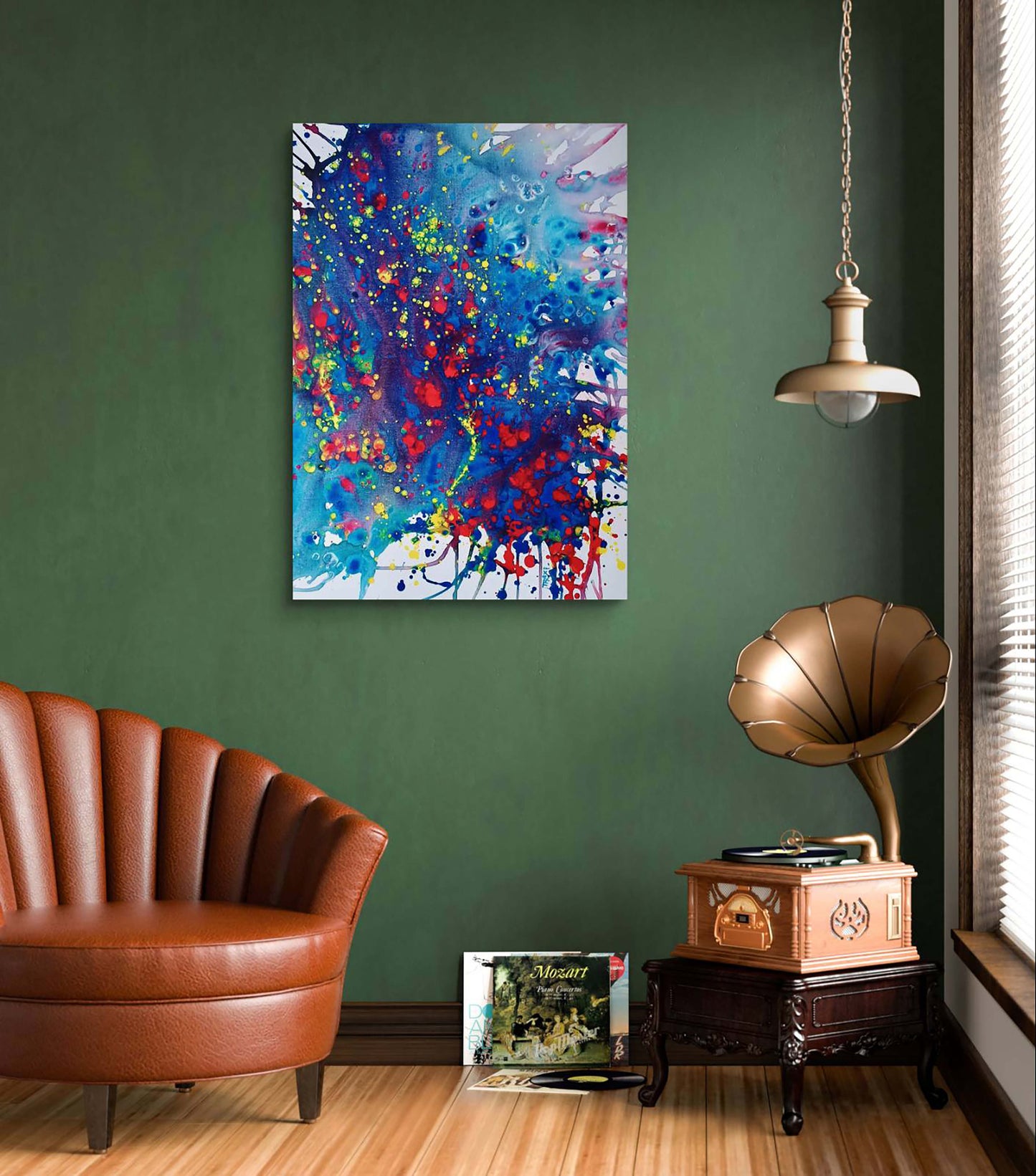  Mood of the Party original vertical abstract fluid acrylic painting with a vibrant blue wave and splashes of red and yellow by Diana Dimova TRAXI ART.A colorful abstract canvas wall art print featuring blue, red, purple, and yellow paint splatters, displayed on a dark green wall in a styled room with a brown leather armchair, a vintage gramophone, and a hanging lamp.