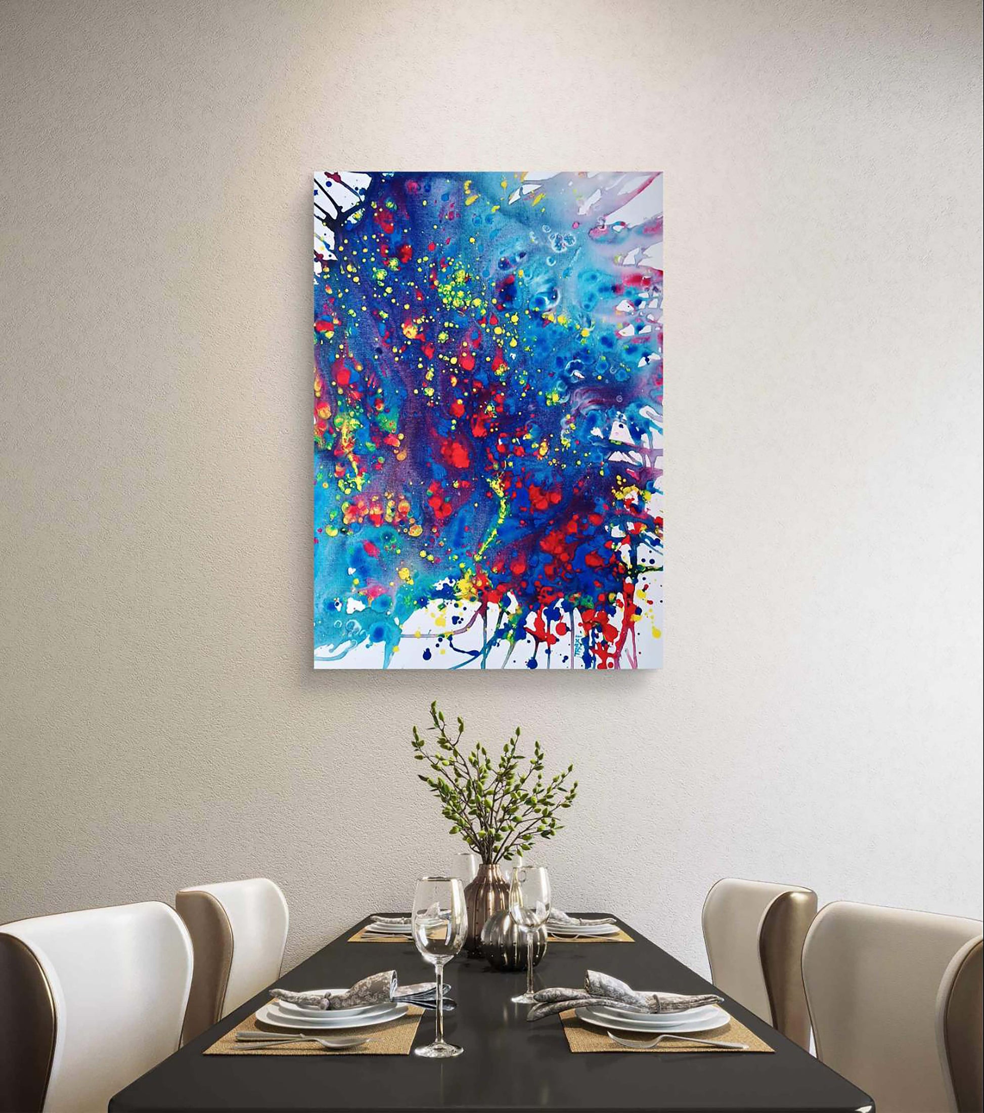 Mood of the Party original vertical abstract fluid acrylic painting with a vibrant blue wave and splashes of red and yellow by Diana Dimova TRAXI ART. An abstract canvas wall art print featuring vibrant splashes of blue, red, yellow, and green paint, displayed on a light beige wall above a modern dining table with chairs and a vase of greenery.