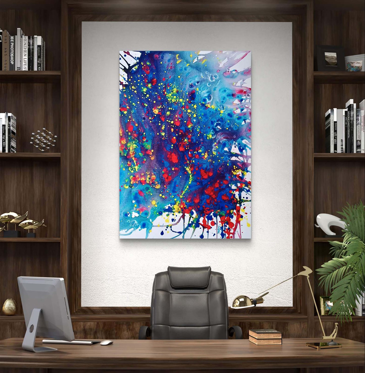 Mood of the Party original vertical abstract fluid acrylic painting with a vibrant blue wave and splashes of red and yellow by Diana Dimova TRAXI ART. A colorful abstract canvas print with blue, red, yellow, and white paint splatters, displayed on a white wall in a modern office setting with a desk, chair, and bookshelves.