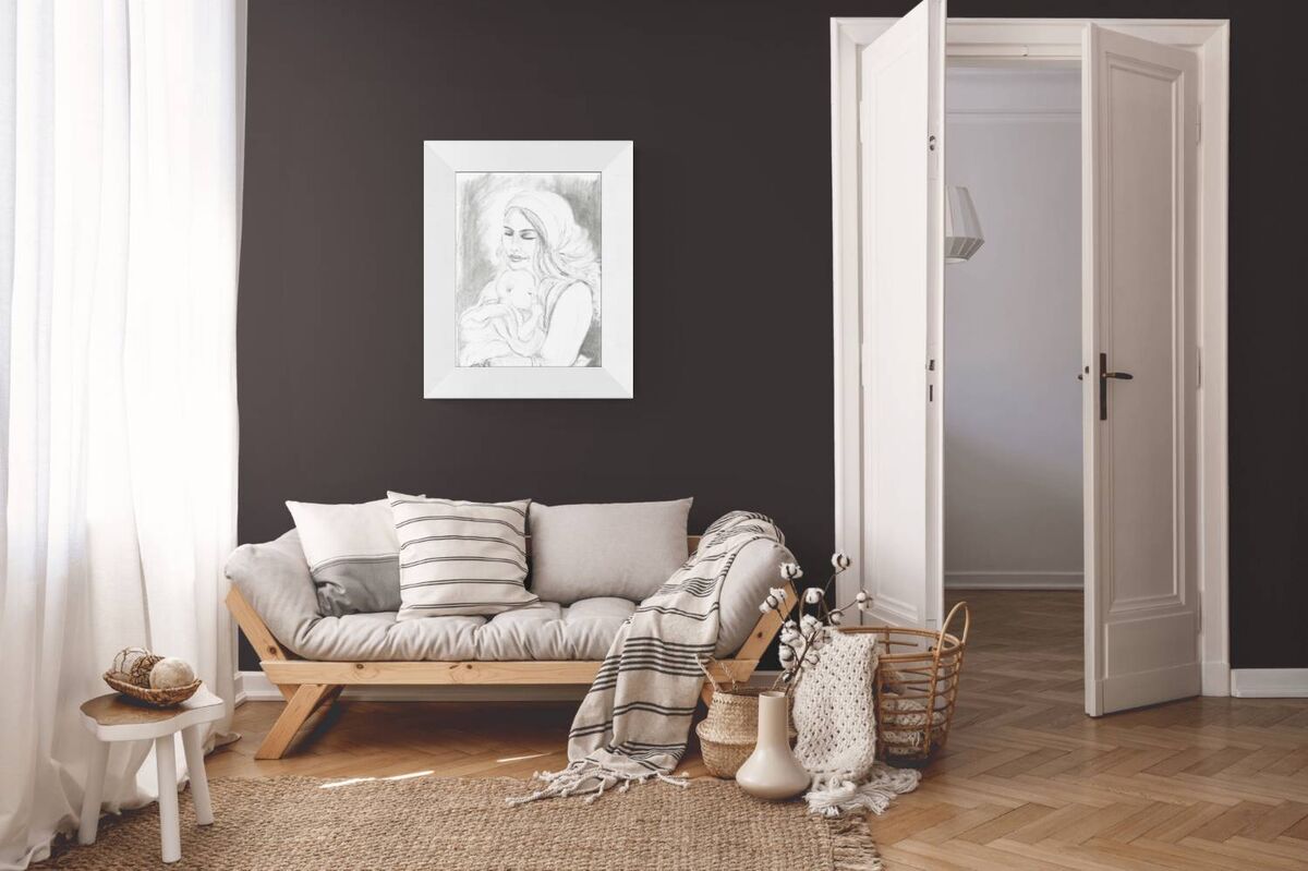 Art Project Connection Mother & Child Painting No. 01, original charcoal sketch by contemporary artist TRAXI. A styled interior room scene with a light wood daybed, gray and white pillows, a striped throw blanket, a woven rug, a small white stool, baskets, and a framed black-and-white portrait hanging on a dark charcoal wall. An open white door is visible on the right.