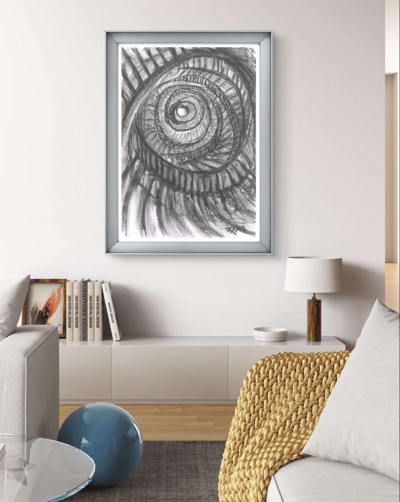 Original monochrome charcoal abstract drawing Eternal Spirals by Diana Dimova TRAXI, featuring rhythmic spiral movements in black and white tones. A framed black and white spiral shell drawing hanging on a light gray wall in a modern living room setting.
