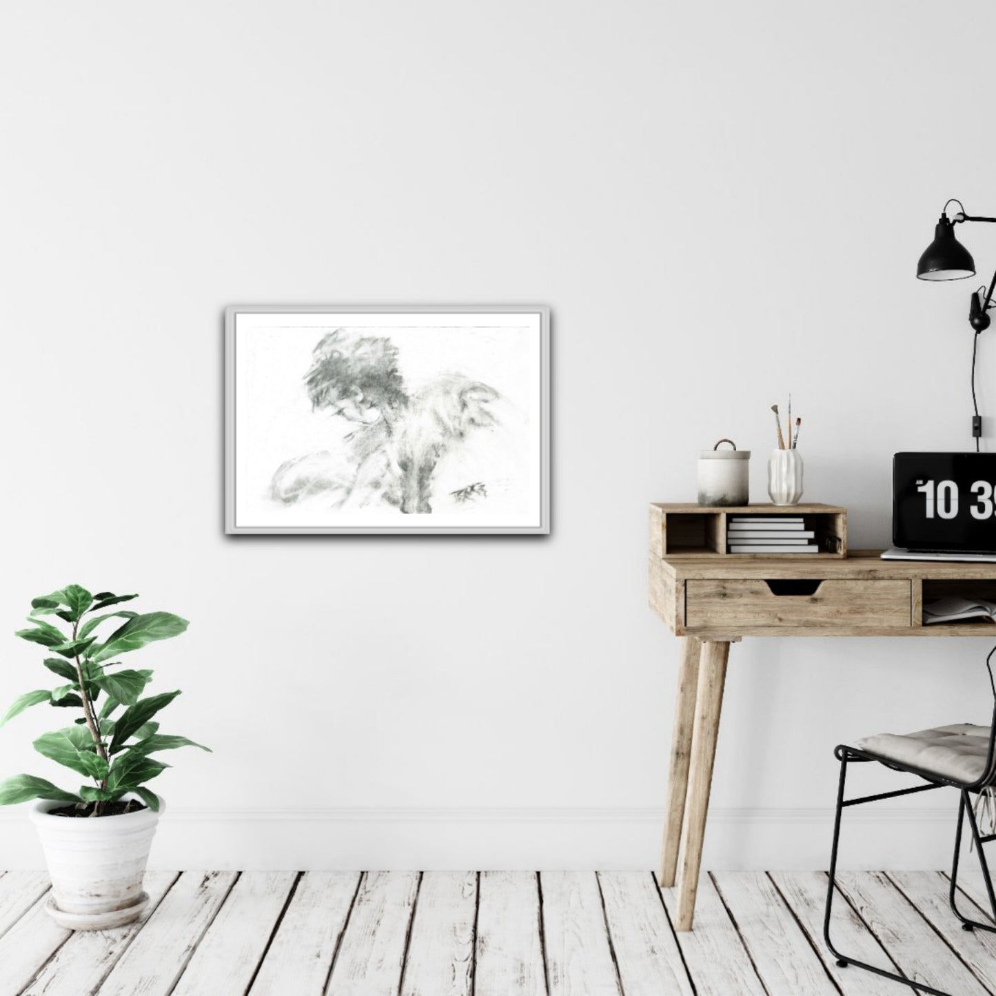 Original monochrome abstract charcoal drawing Rebirth by Diana Dimova TRAXI, featuring black and white contrasts celebrating nature and renewal. A framed black and white sketch print of a classical figure is displayed on a white wall in a modern, minimalist room setting with a wooden desk, lamp, and potted plant.