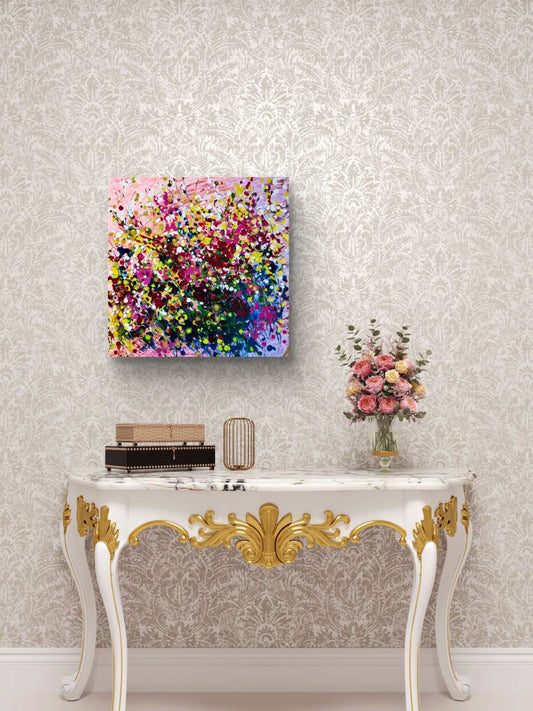Limited edition canvas print of Summer Garden Flowers by Diana Dimova TRAXI, featuring a colorful floral bouquet in vibrant tones.  A colorful abstract canvas painting with vibrant pink, yellow, blue, and purple brushstrokes, displayed on a light gray damask wallpapered wall above an ornate white and gold console table with a vase of flowers.