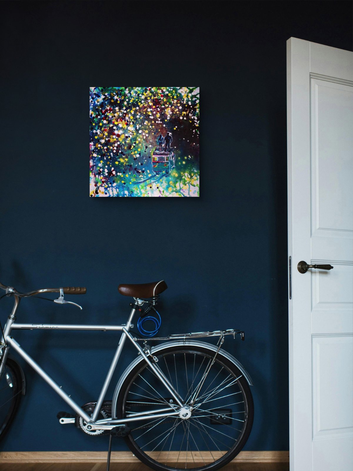 Original Painting, Pointillism, TRAXI, Spiritual Abstract, Vintage Bus, Starry Night, Romance, Contemporary Art, Wall Decor, Triptych, Collectible Art A square abstract canvas print with a colorful bokeh light pattern hangs on a dark navy blue wall above a silver bicycle and next to a white door.