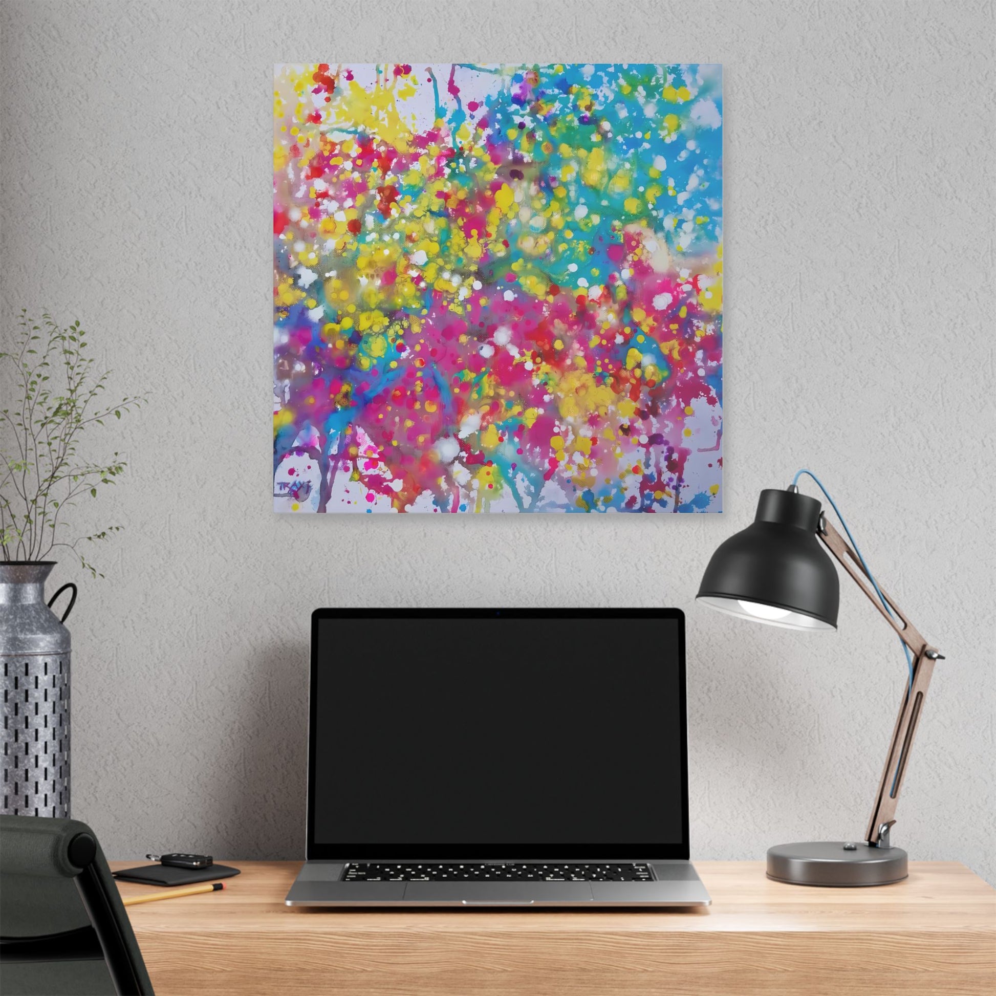 Painting of happiness 2 vibrant abstract canvas print by award-winning contemporary artist Diana Dimova - TRAXI, featuring radiant pink, yellow, and blue colors. A colorful abstract tree artwork hanging on a light gray wall above a wooden desk with an open laptop, a black desk lamp, and a decorative vase.