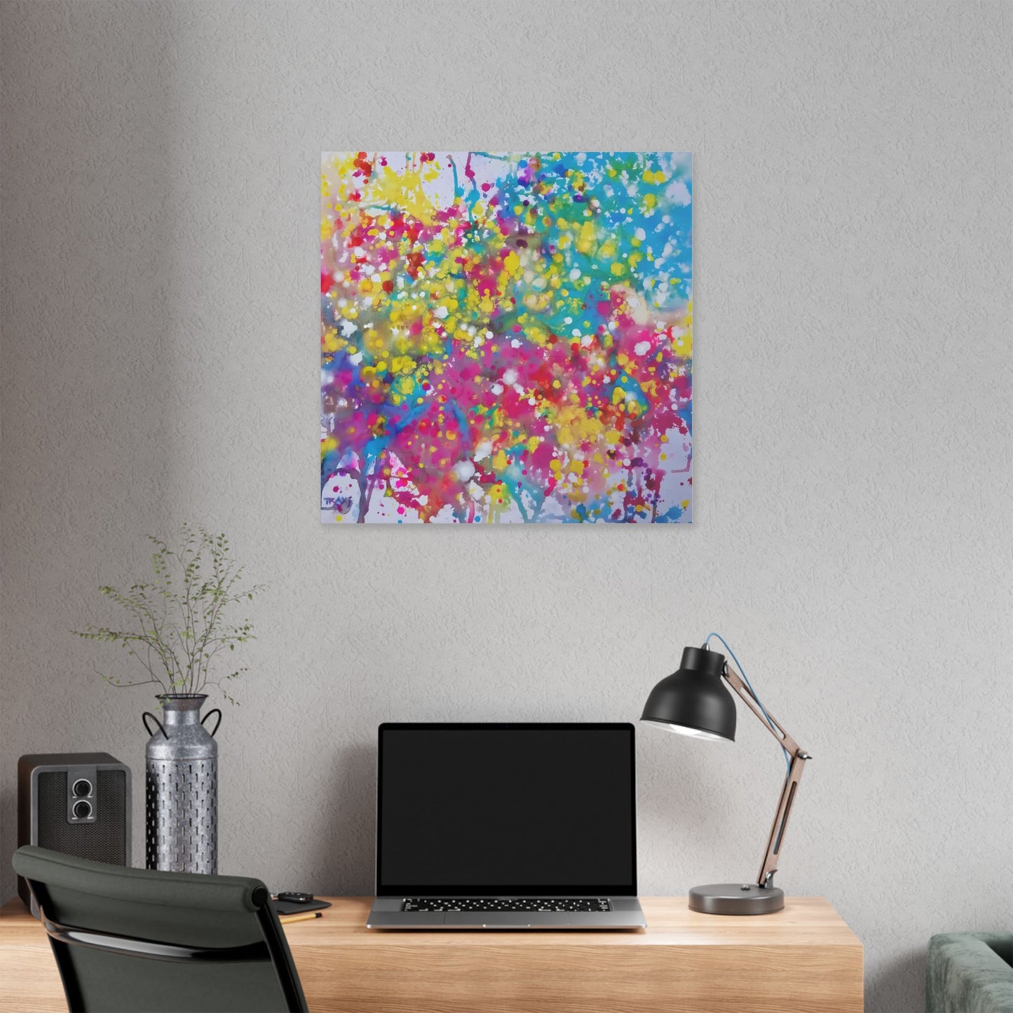  Painting of happiness 2 vibrant abstract canvas print by award-winning contemporary artist Diana Dimova - TRAXI, featuring radiant pink, yellow, and blue colors. A colorful abstract canvas print of a tree with vibrant pink, yellow, blue, and green brushstrokes, displayed on a light gray wall above a wooden desk with a laptop, lamp, and vase.