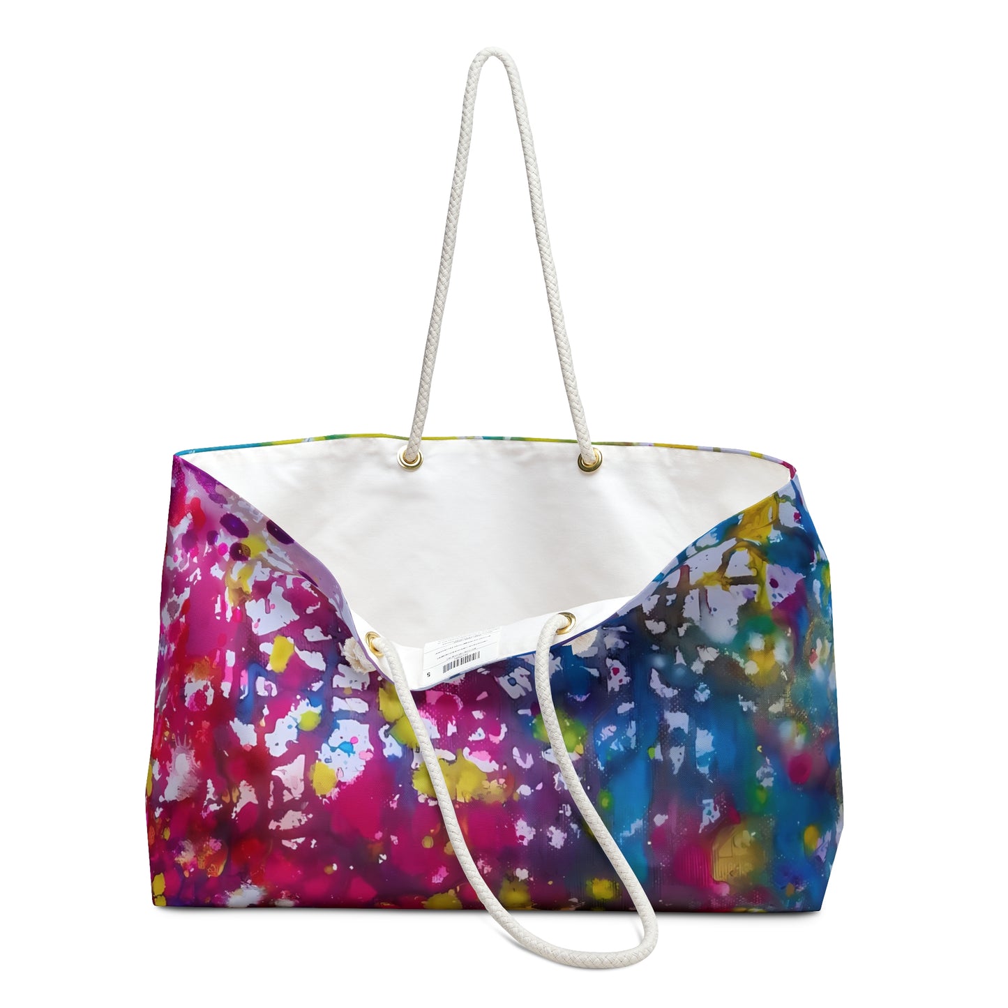 Paintings of happiness beach bag featuring vibrant wearable art inspired by the Paintings of Happiness series by Diana Dimova TRAXI. A canvas tote bag with a vibrant multicolor paint splatter pattern on the exterior, a white canvas interior, and thick white rope handles, shown against a plain white background.