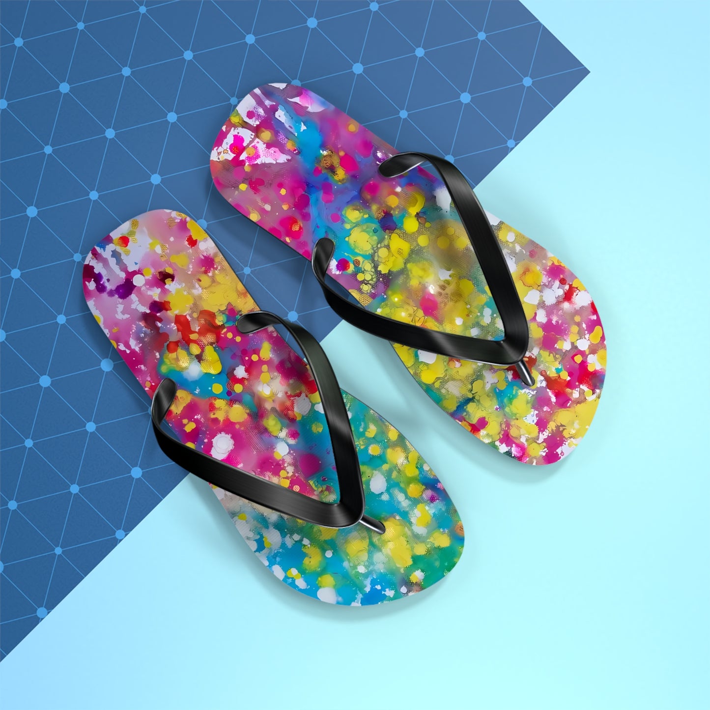 Summer beach flip flops of happiness featuring abstract wearable art inspired by the Paintings of Happiness series by Diana Dimova TRAXI. A pair of colorful abstract-print flip-flops with black straps, arranged diagonally on a split blue and light blue background.