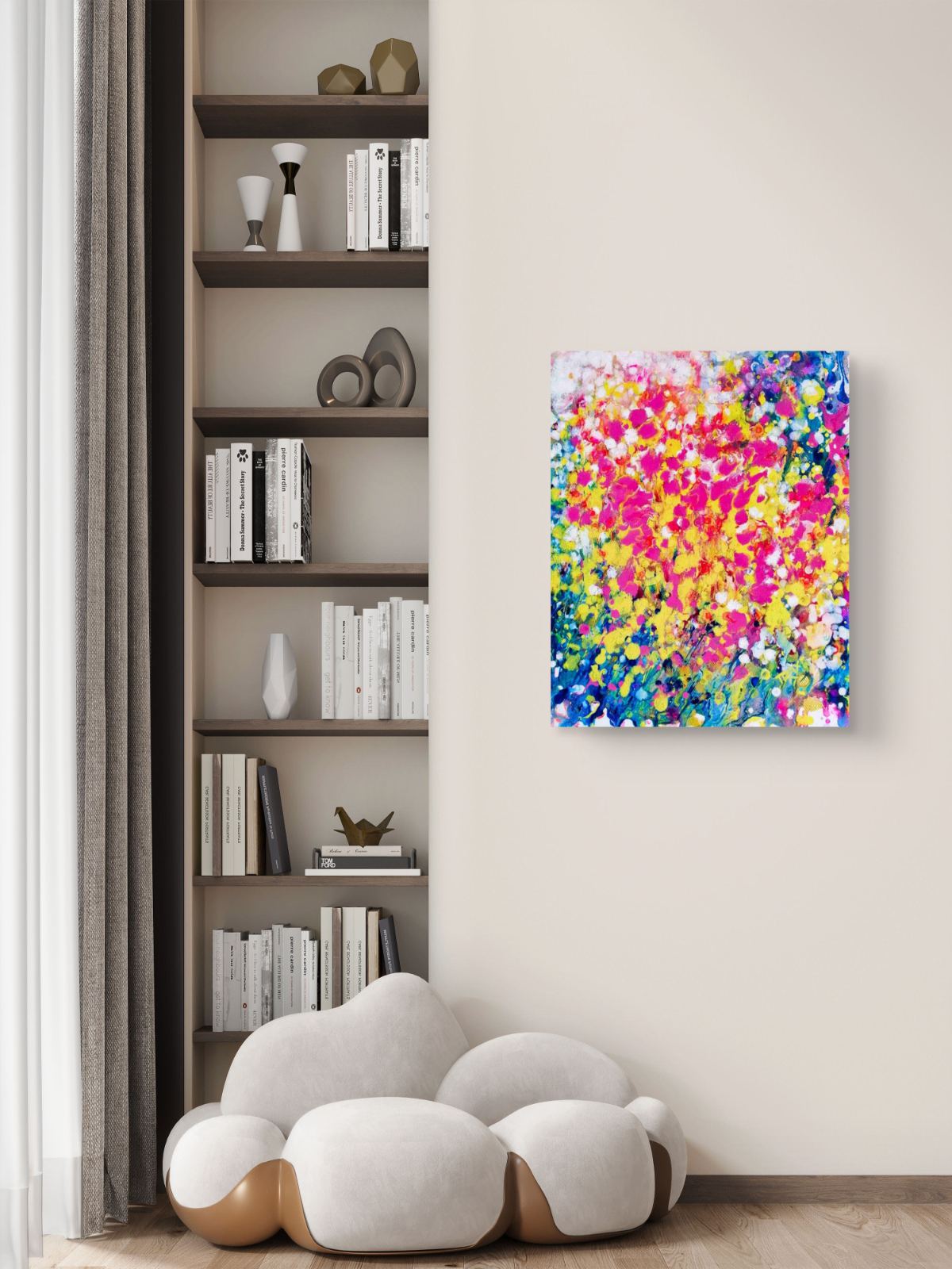 Summer flowers limited edition canvas print by contemporary artist TRAXI, featuring vibrant abstract fluid acrylic colors and warm seasonal energy in a 50x60 cm format. A colorful abstract canvas art print featuring vibrant splatters of pink, yellow, blue, and white, displayed on a beige wall in a modern living room setting next to a built-in bookshelf and a cloud-shaped white sofa.