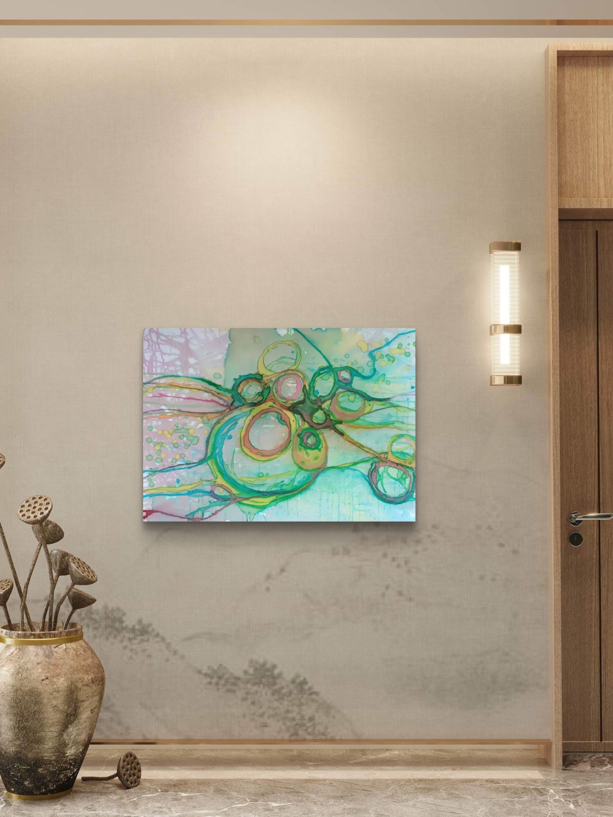 Original abstract painting titled 'The Balance' by TRAXI featuring serene textures and organic rhythms. The artwork represents the culmination of the series States of Becoming, exploring harmony, nature, and spiritual equilibrium. An abstract canvas painting with swirling green, teal, and gold brushstrokes on a light blue and white background, displayed on a beige wall in a modern interior setting next to a wooden door and a wall sconce.