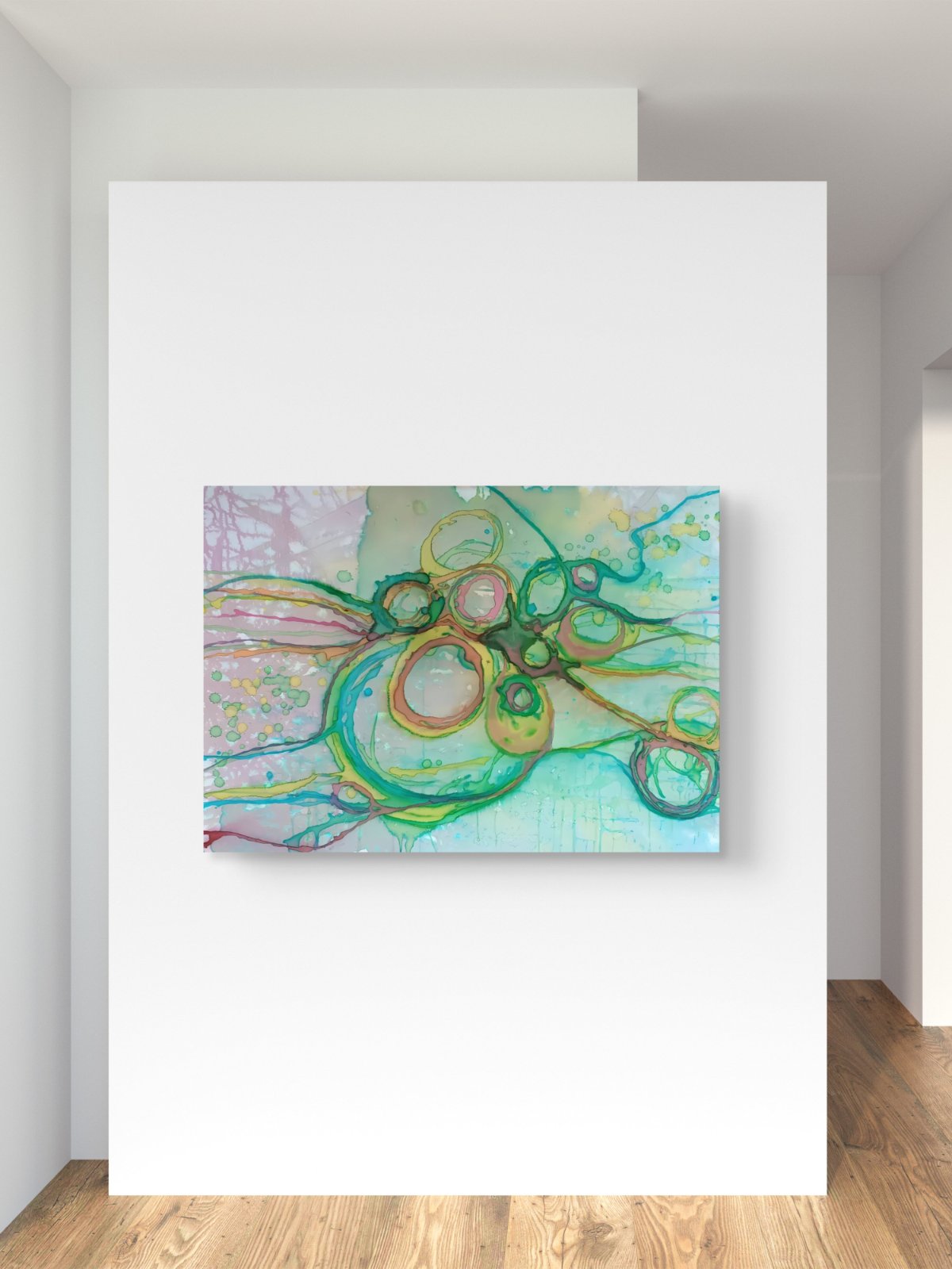 Original abstract painting titled 'The Balance' by TRAXI featuring serene textures and organic rhythms. The artwork represents the culmination of the series States of Becoming, exploring harmony, nature, and spiritual equilibrium. An abstract canvas wall art print featuring green, teal, and gold circular patterns on a light blue and yellow background, displayed on a white wall above a wooden floor.