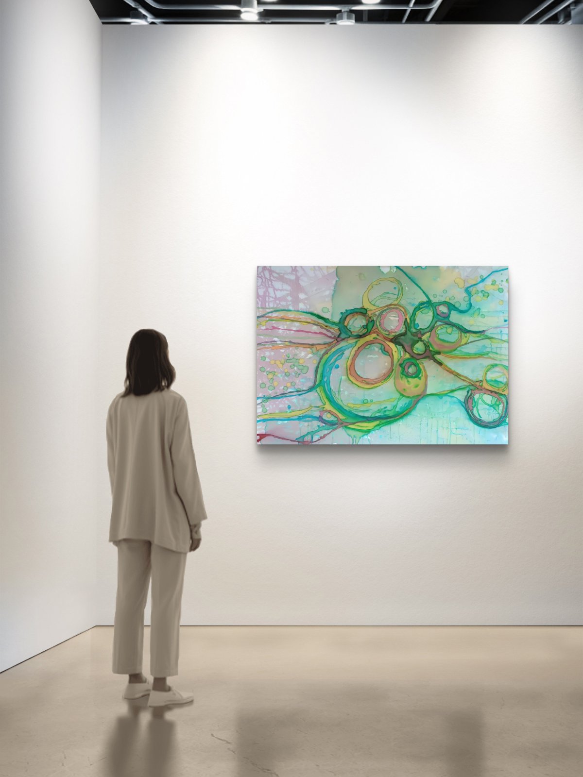 Original abstract painting titled 'The Balance' by TRAXI featuring serene textures and organic rhythms. The artwork represents the culmination of the series States of Becoming, exploring harmony, nature, and spiritual equilibrium. A woman in a beige tracksuit stands with her back to the camera, looking at a large abstract painting hanging on a white gallery wall. The painting features flowing, organic shapes in shades of green, teal, yellow, and pink.