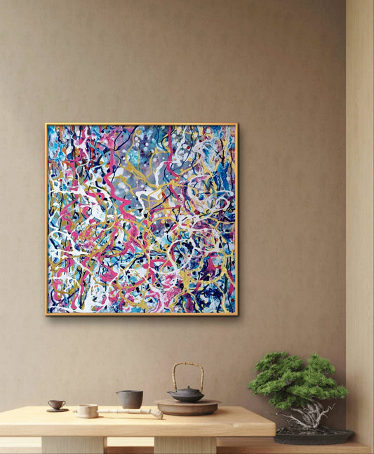 The Braid of Life art in action limited edition abstract print by contemporary artist Diana Dimova TRAXI. A square abstract painting with a gold frame hangs on a beige wall above a light wood table styled with a teapot, cups, and a small bonsai tree.