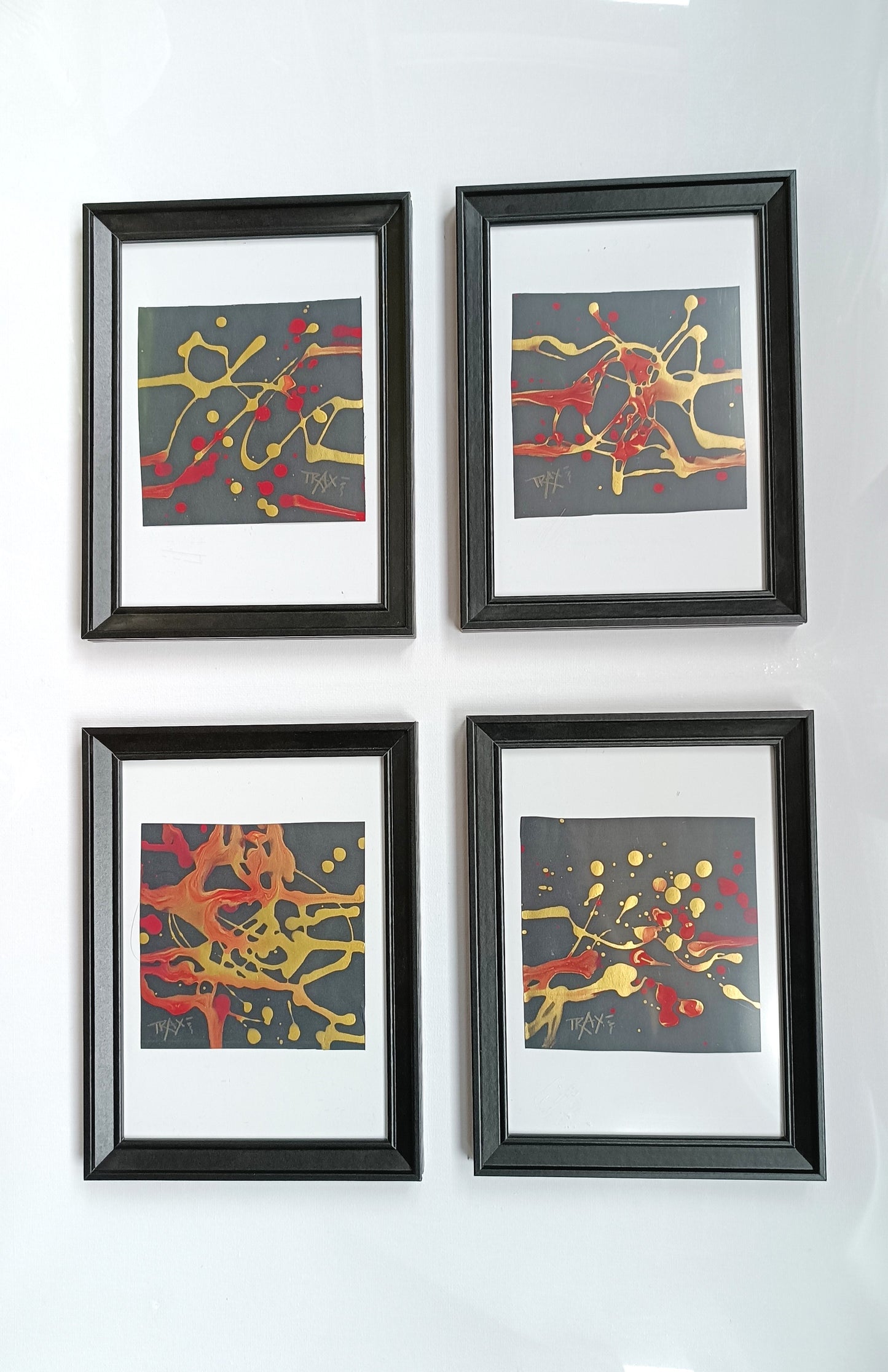 The complete SIGNS art collection by Diana Dimova - TRAXI, featuring all four abstract miniature paintings in luxury black frames displayed together.