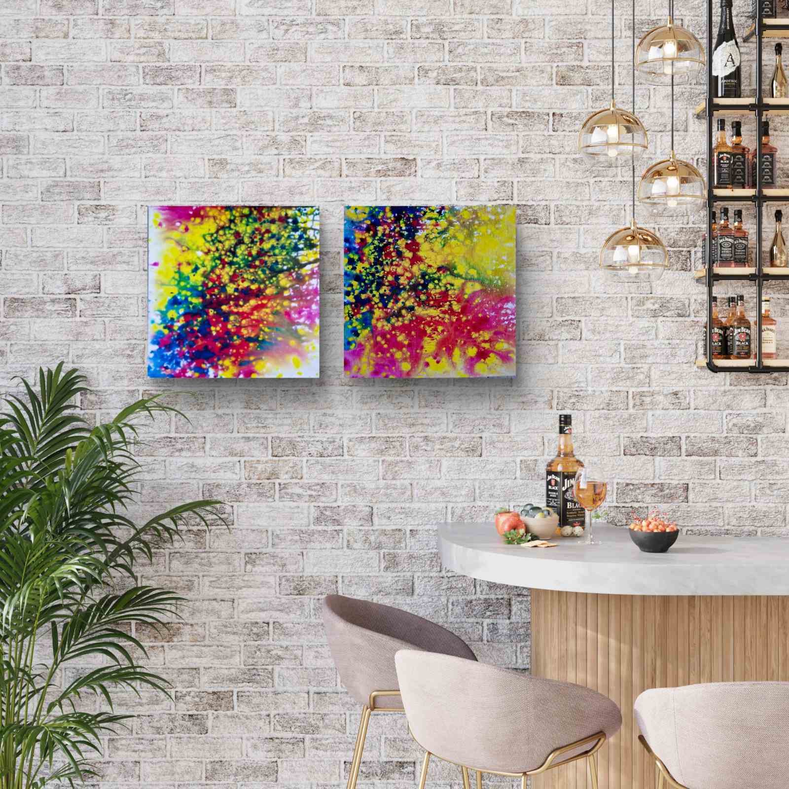 Fires Set original fluid acrylic abstract diptych in blue, red, orange, and yellow by Diana Dimova TRAXI ART. Finalist Award winner 2025. Two square abstract canvas prints with vibrant multicolor splatters hang on a light gray brick wall above a modern bar counter with chairs and hanging pendant lights.