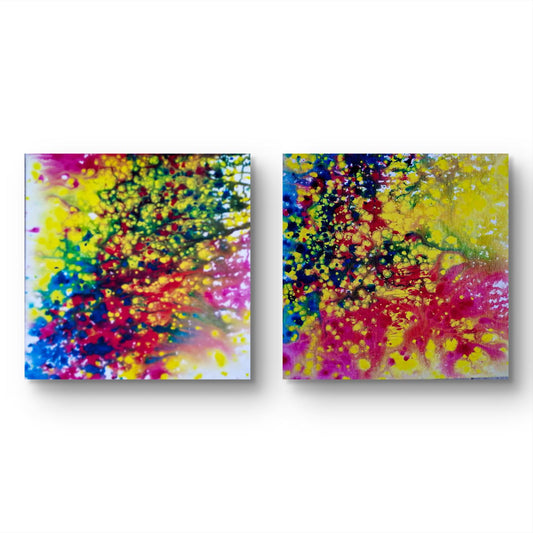 Fires Set limited edition premium canvas diptych print with vibrant blue, red, orange, and yellow energy by Diana Dimova TRAXI ART.  Two square abstract wall art panels with vibrant splattered paint in yellow, pink, red, blue, green, and black on a white background.