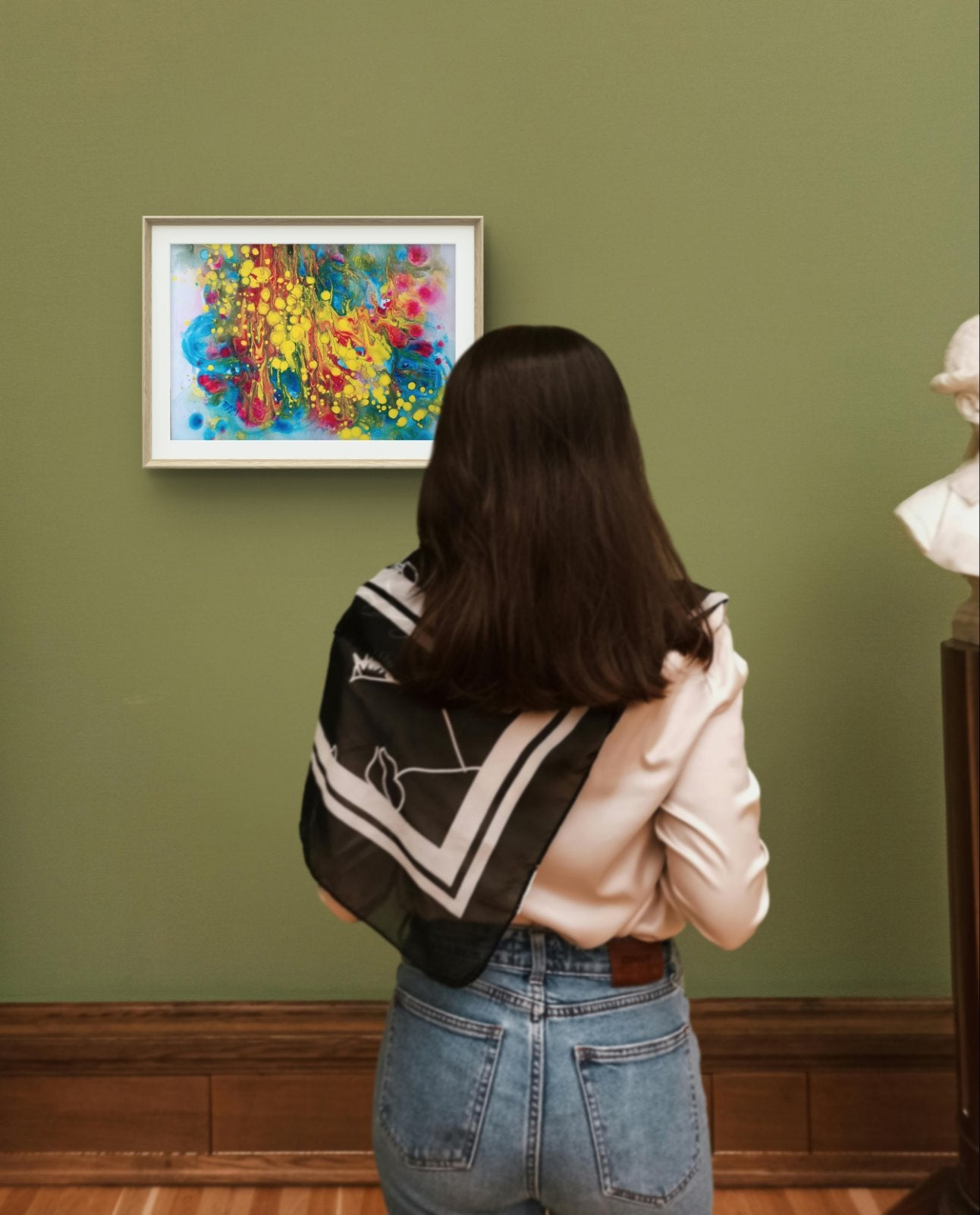 Fountains of Youth original watercolor abstract painting by Diana Dimova TRAXI ART, featuring dynamic yellow, blue, green, and red strokes. A woman viewed from behind stands in a gallery or museum, looking at a colorful abstract painting on a green wall. She is wearing a black and white patterned scarf, a light pink top, and blue jeans.