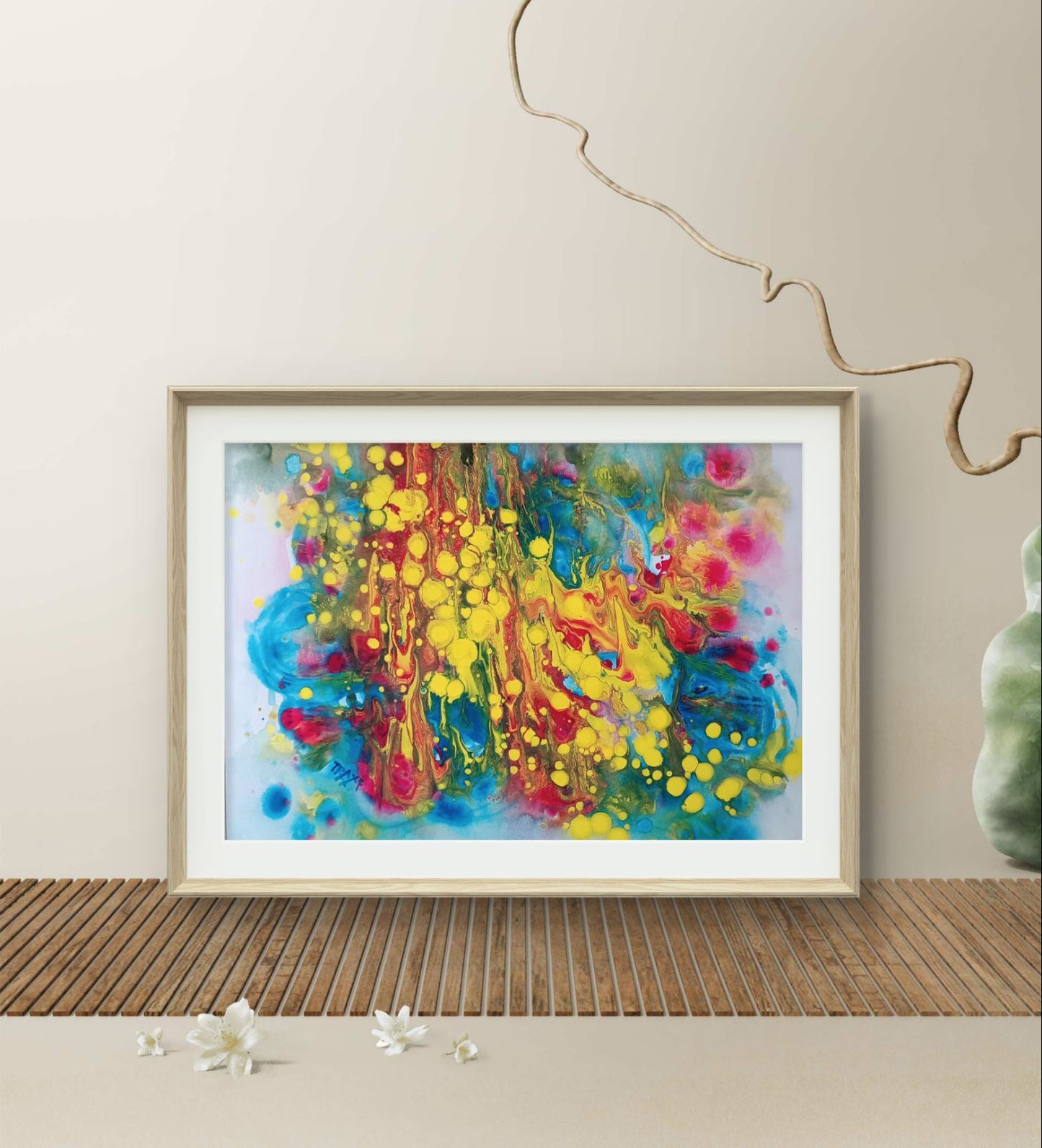 Fountains of Youth original watercolor abstract painting by Diana Dimova TRAXI ART, featuring dynamic yellow, blue, green, and red strokes. A framed abstract art print featuring vibrant splashes of yellow, blue, red, and pink paint on a light background, styled in a minimalist room setting with a wooden slatted surface and neutral wall.