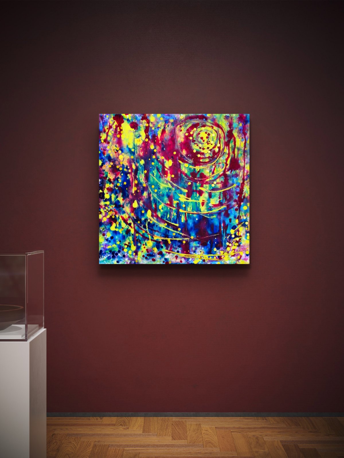 Lighthouse Bold Colorful Abstract painting by Diana Dimova TRAXI ART, featuring vibrant light rays emerging from dark textures. A square abstract canvas print with a vibrant multicolor design featuring concentric spiral patterns in red, yellow, blue, green, and purple, displayed on a dark reddish-brown gallery wall above a wooden floor.