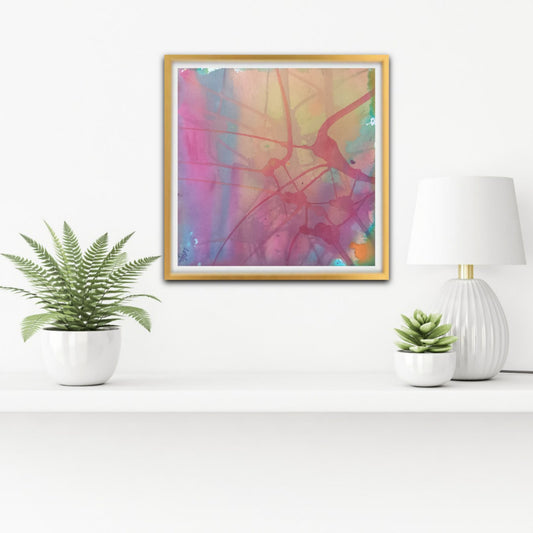 Nuances of Time limited edition premium square canvas print with soft pastel pink and violet tones by Diana Dimova TRAXI ART. A square framed abstract art print with a gold frame hangs on a white wall above a shelf. The artwork features a colorful blend of pink, purple, yellow, and blue with organic line patterns.
