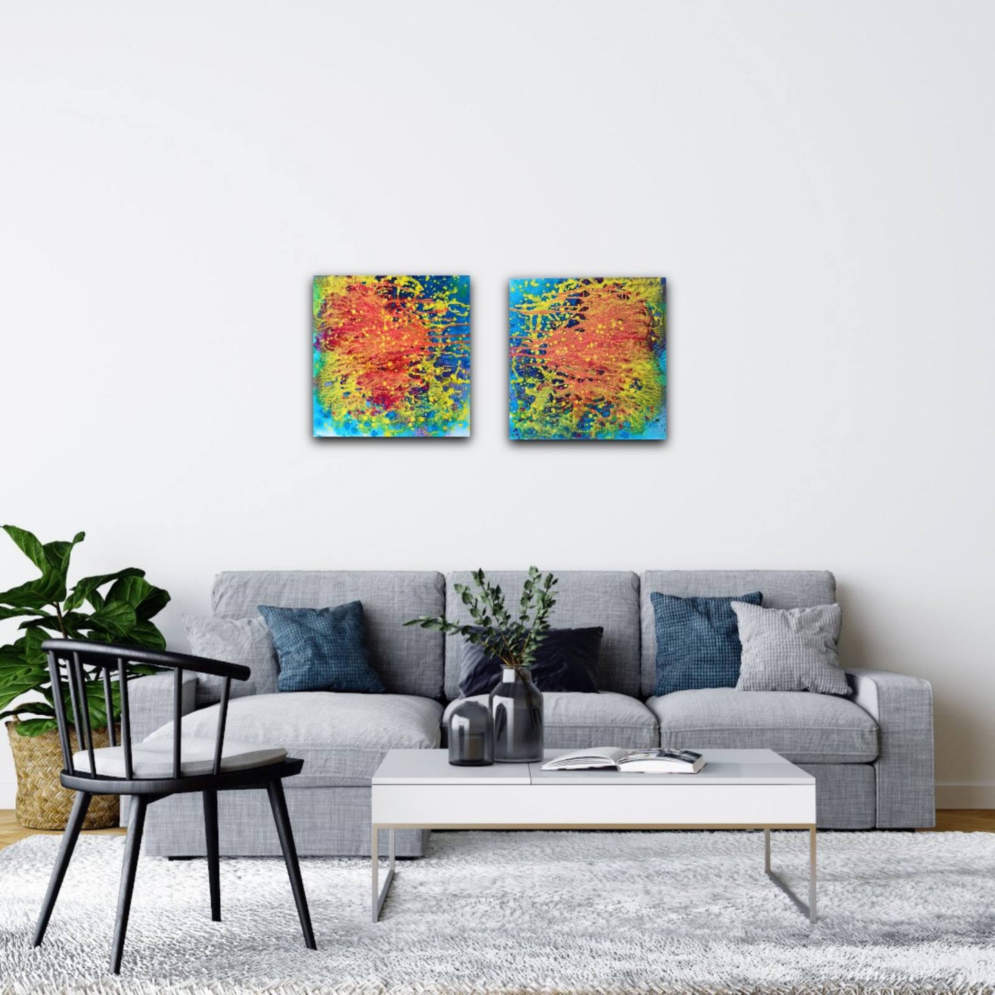Portals of the Sun original cosmic abstract diptych in orange and yellow by Diana Dimova TRAXI ART. Bronze Award winner 2024. A modern living room setting featuring a pair of square abstract canvas prints with vibrant red, orange, yellow, and blue brushstrokes, hung side-by-side on a white wall above a gray sofa.