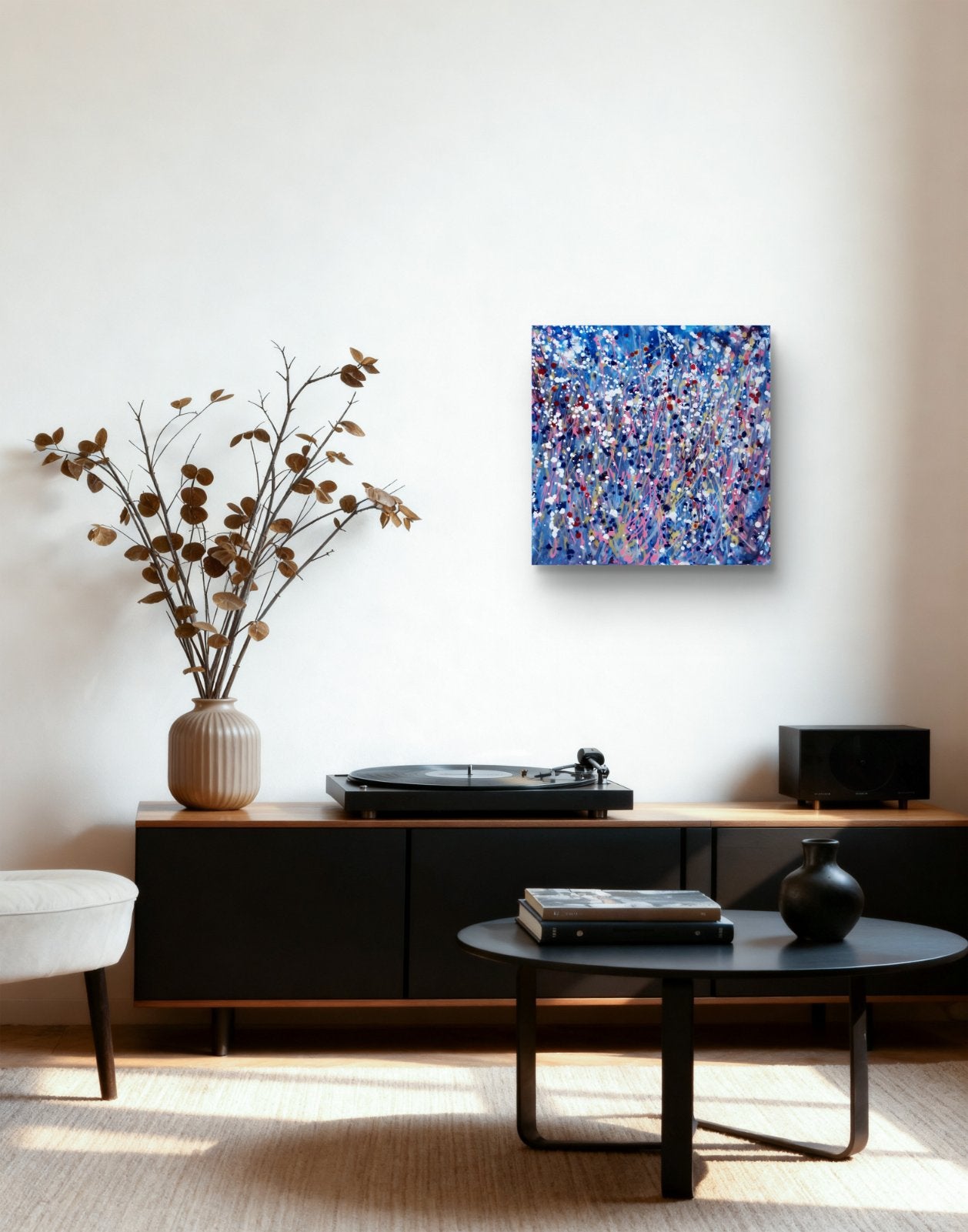 Starlight in the Grass original abstract square painting with calm blue, soft pink, and silver starlight tones by Diana Dimova TRAXI ART. A square abstract canvas print with a vibrant blue, purple, and pink textured pattern hanging on a white wall in a modern living room setting above a black media console.