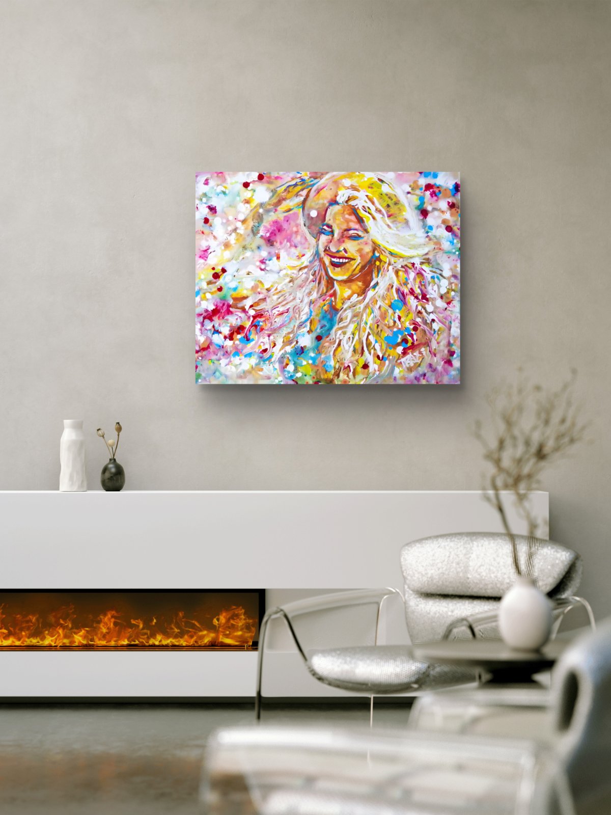 A colorful abstract portrait canvas print of a woman with blonde hair, displayed on a light gray wall above a white fireplace in a modern living room setting. Sun in the Hair limited edition premium horizontal canvas print depicting a smiling woman in a straw hat with pink and yellow summer light by Diana Dimova TRAXI ART.
