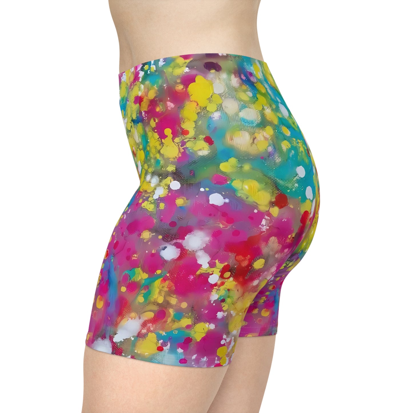 Women's summer biker shorts of happiness featuring abstract wearable art inspired by the Paintings of Happiness series by Diana Dimova TRAXI. A side view of a person wearing high-waisted biker shorts with a vibrant, multicolored paint splatter pattern on a solid white background.