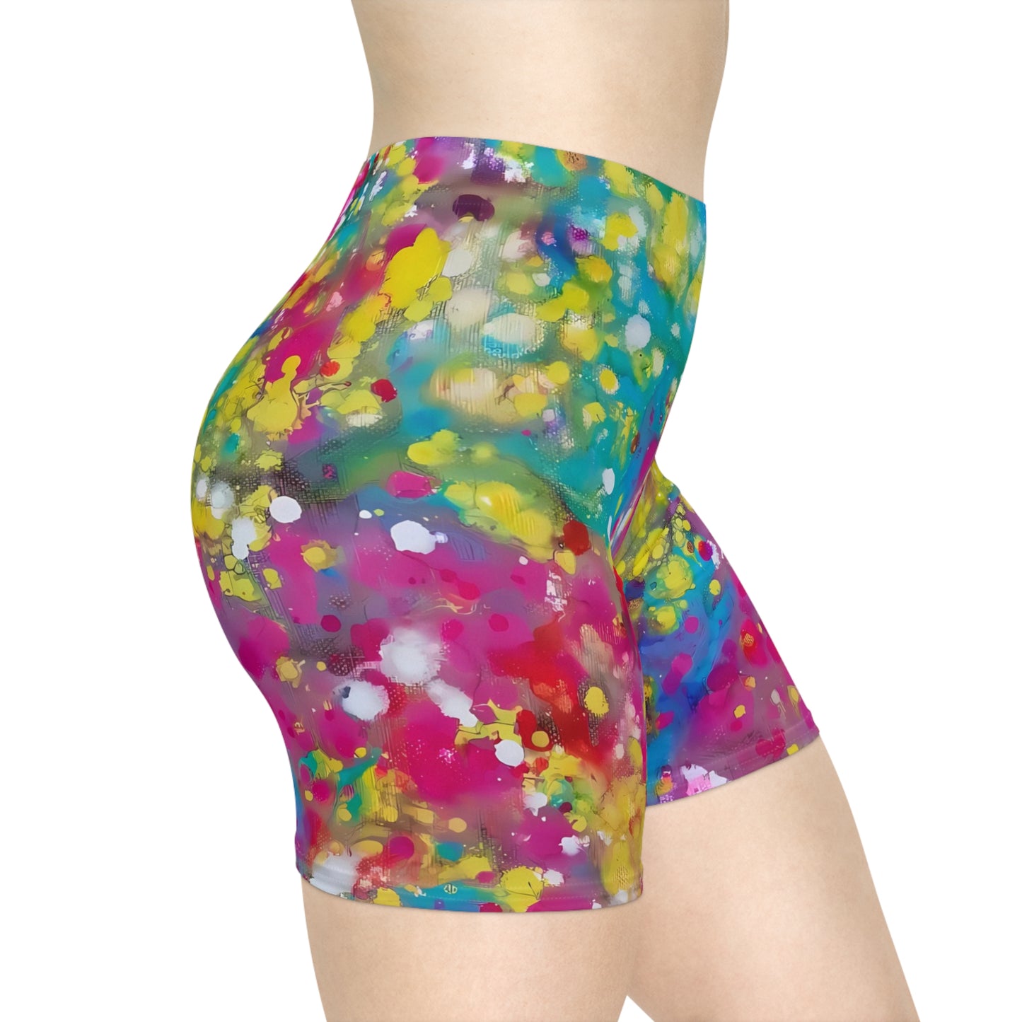 Women's summer biker shorts of happiness featuring abstract wearable art inspired by the Paintings of Happiness series by Diana Dimova TRAXI. A person wearing high-waisted biker shorts with a bright multicolor abstract paint-splatter pattern in pink, yellow, blue, green, and white on a plain white background.
