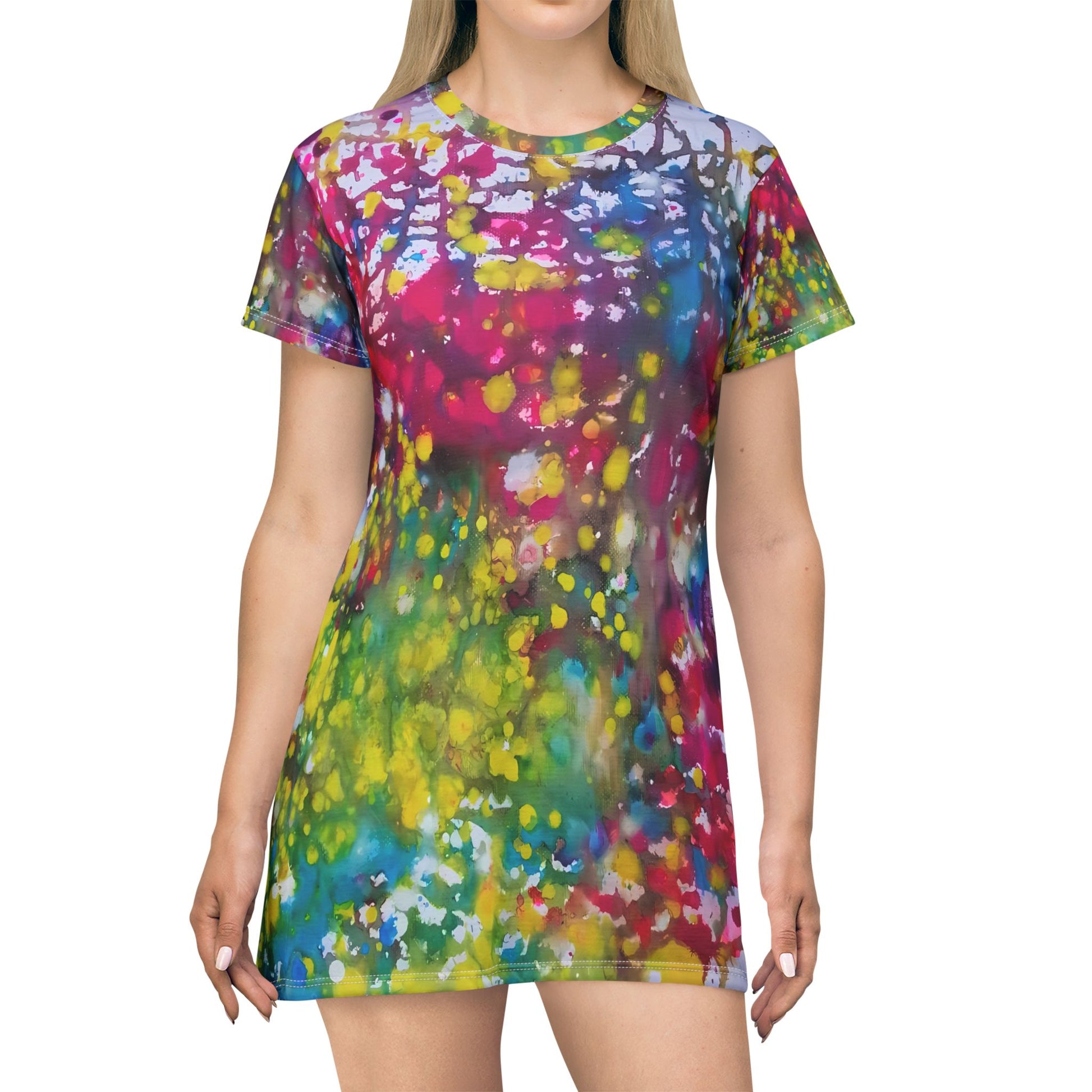 Women's summer t-shirt dress of happiness featuring abstract wearable art by Diana Dimova TRAXI. A woman wearing a short-sleeve crewneck t-shirt dress with a vibrant multicolor tie-dye splatter pattern, shown against a plain white background.